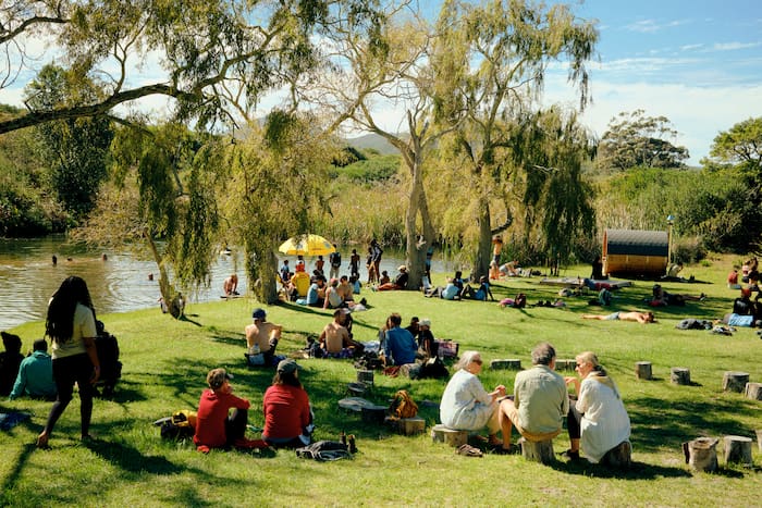 attendees at Greenpop relaxing by the lake, saving the planet. 