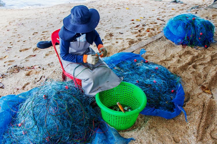 A lady repairing a fishnet.