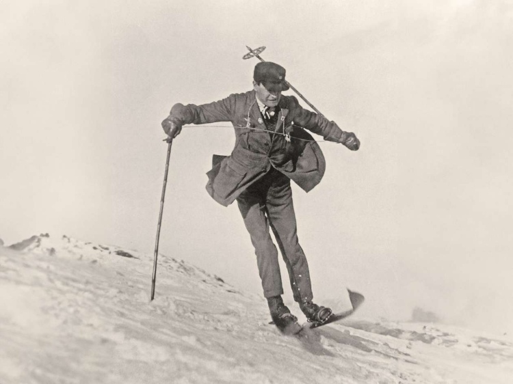 Sir Arnold Lunn in motion, immaculately dressed in jacket, tie and cap