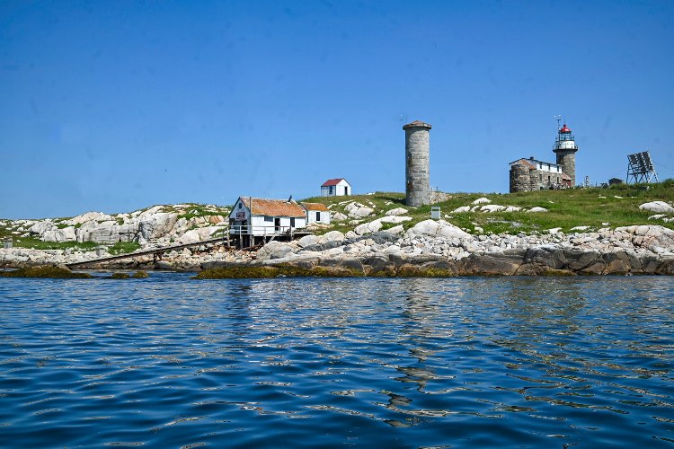 View of Matinicus Rock, the landing area for Audubon Society boats, and in the background, the lighthouse and house where Abbie Burgess and her family lived from1853 to 1875.  Her father was the lighthouse keeper.